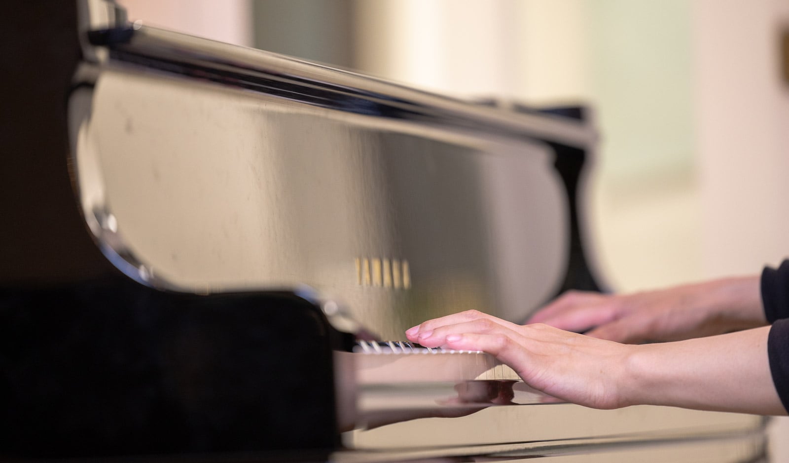 Close up of an adult student's hands reading music at the piano during a class in Downtown Boston