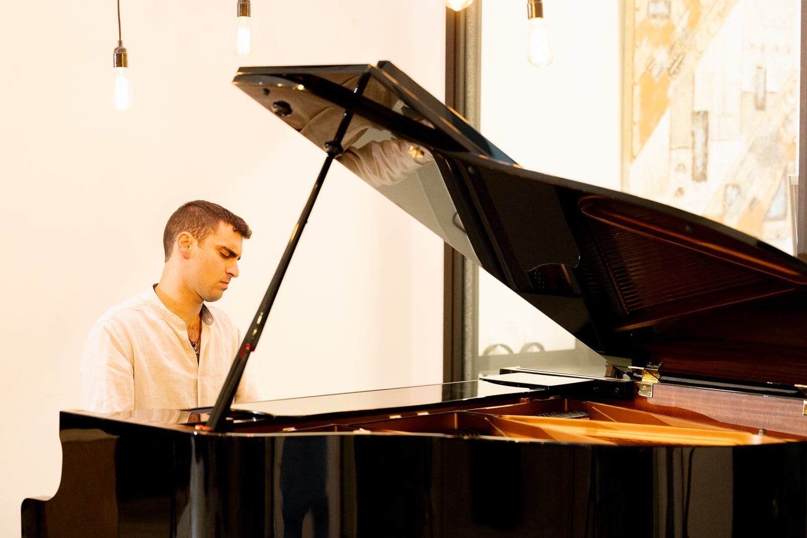Adult piano student reading music at a grand piano in Downtown Boston