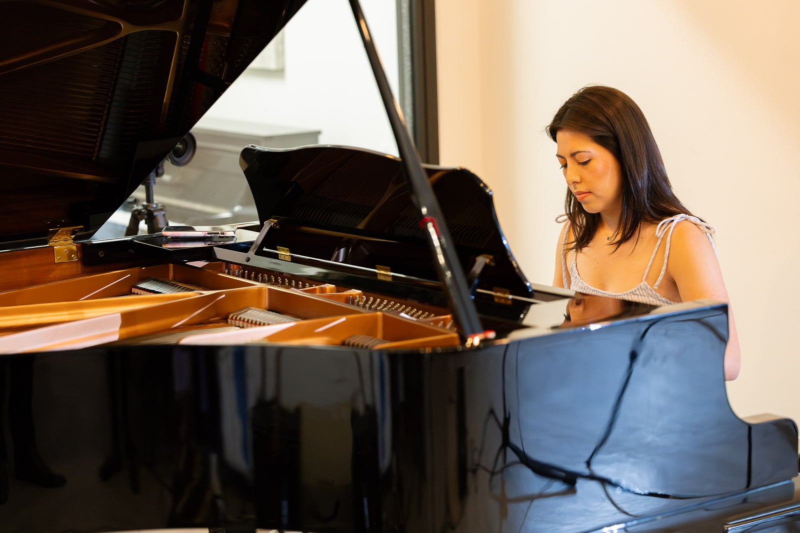 Adult piano student playing a grand piano at Musicians Playground in Downtown Boston