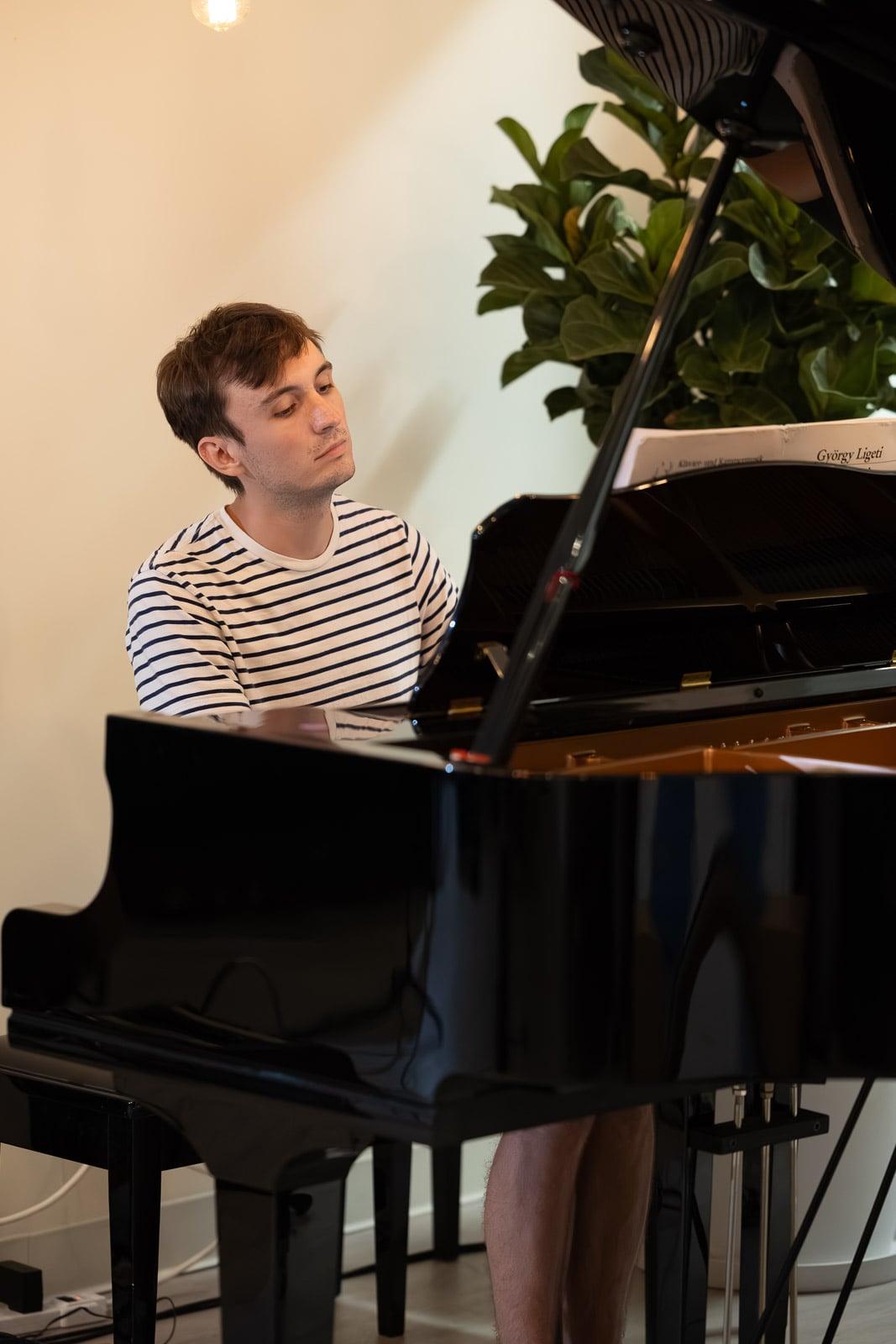 Adult pianist playing a grand piano in the piano studio in Downtown Crossing