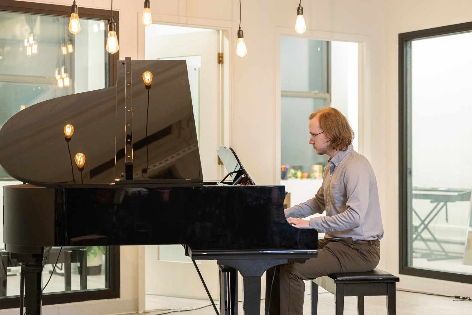 Adult piano student playing a grand piano in the studio at Musicians Playground