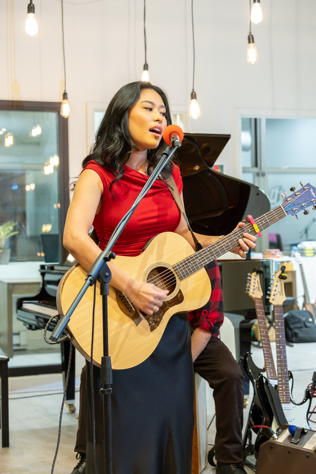 Two adult voice students singing beside the piano in the Downtown Crossing studio